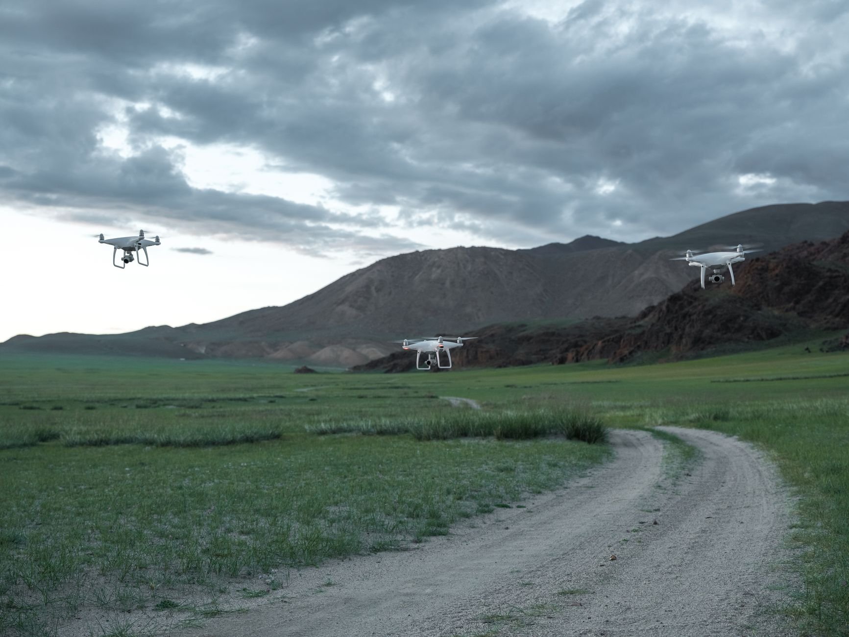 Drone with thermal payload flying a night search pattern over forested hills