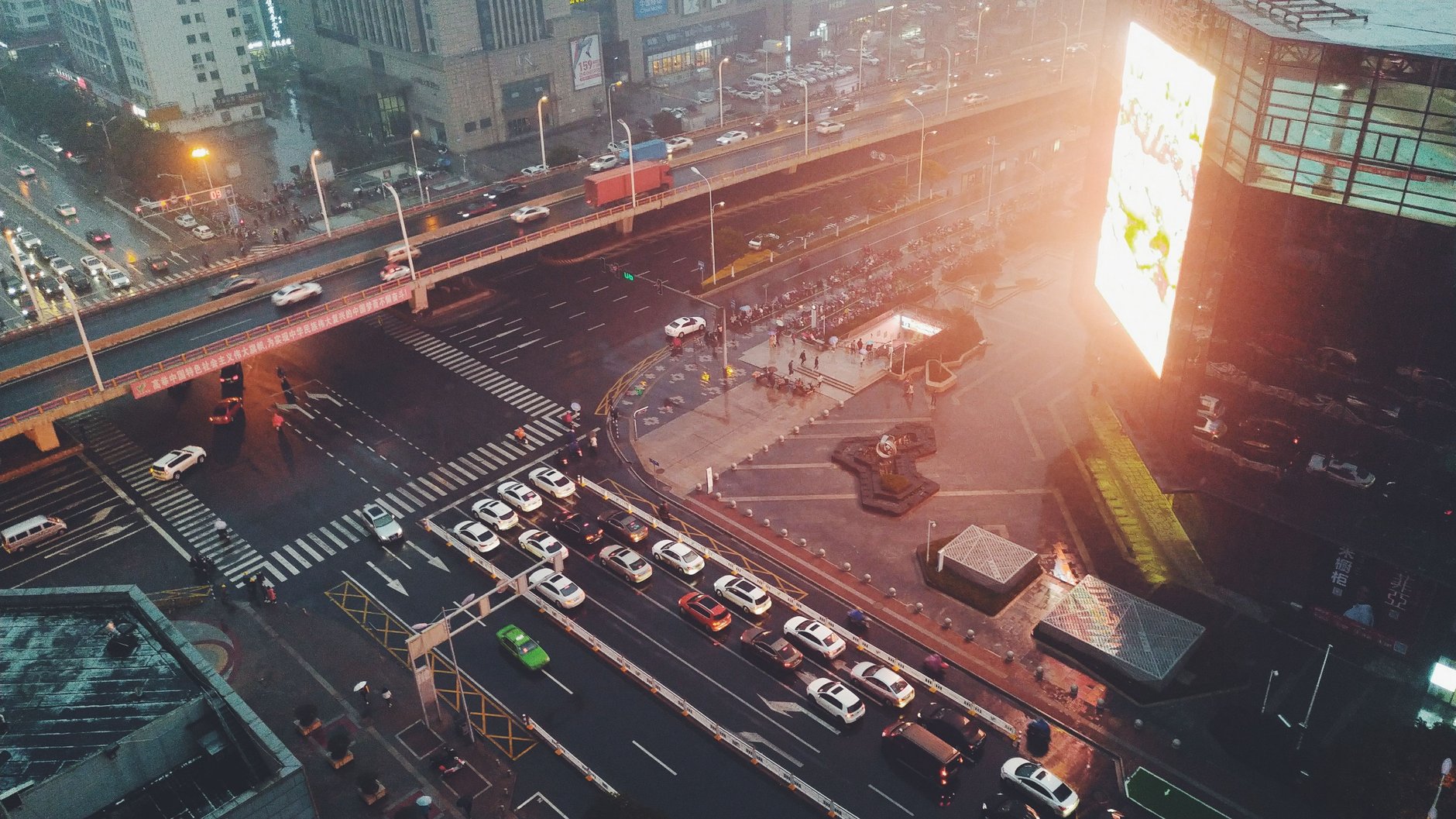 Busy urban arterial at dusk with mixed traffic at a major intersection